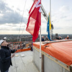 Man hijst vlag op het hoogste punt van het Walkwartier in Oss